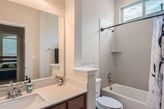 full bathroom featuring vanity, shower / bath combo, and toilet