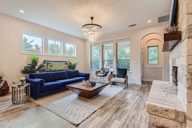 living room featuring a chandelier, light hardwood / wood-style flooring, and a fireplace