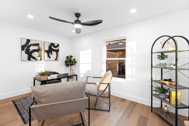 living area with ceiling fan and light hardwood / wood-style flooring