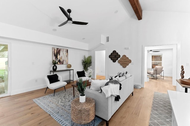 living room featuring lofted ceiling with beams, light hardwood / wood-style flooring, ceiling fan, and a healthy amount of sunlight