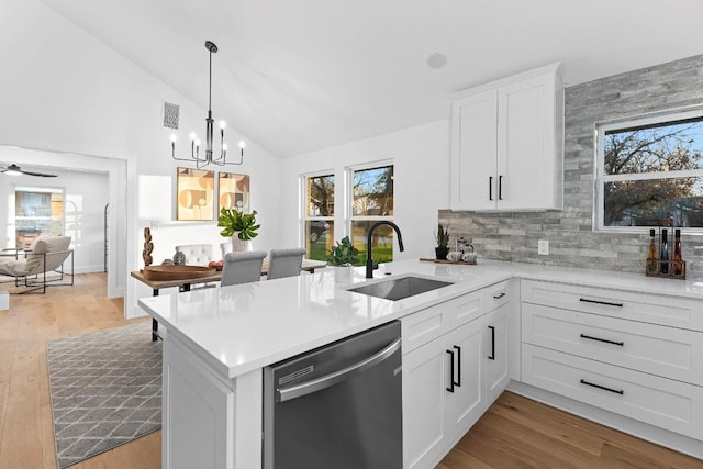 kitchen with kitchen peninsula, stainless steel dishwasher, a healthy amount of sunlight, and sink