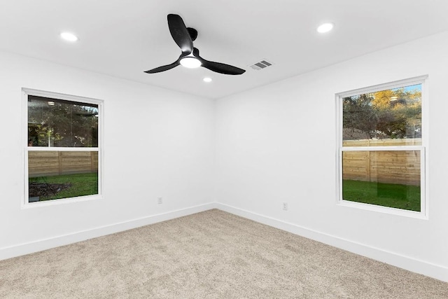 unfurnished room with ceiling fan and carpet