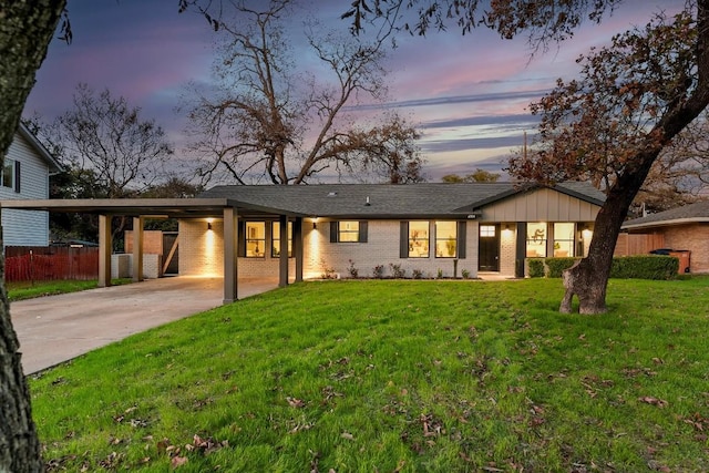 view of front of property featuring a lawn and a carport