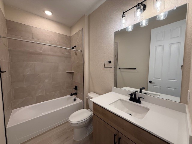 128 Alistair Dr, Georgetown, TX 78633 - full bathroom with toilet, vanity, shower / tub combination, wood finished floors, and a textured wall