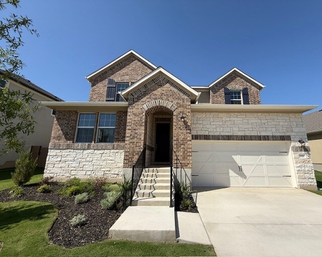 128 Alistair Dr, Georgetown, TX 78633 - view of front of home with driveway, brick siding, a garage, and stone siding