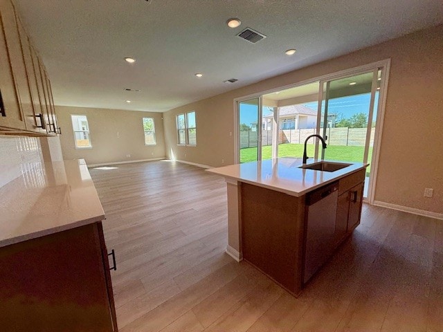 128 Alistair Dr, Georgetown, TX 78633 - kitchen with a sink, light wood-style flooring, light countertops, baseboards, and dishwasher