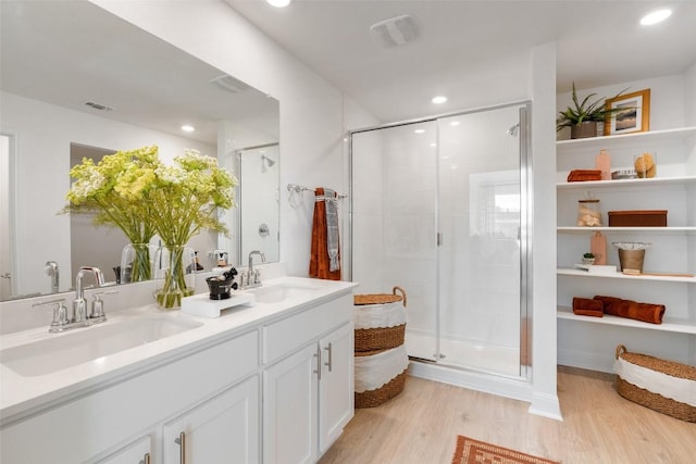 bathroom with hardwood / wood-style floors, vanity, and an enclosed shower