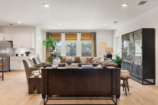 living room featuring a textured ceiling and light wood-type flooring