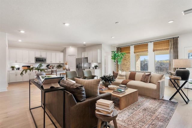 living room featuring a textured ceiling and light hardwood / wood-style floors