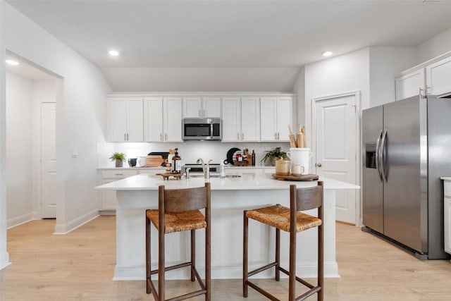 kitchen featuring backsplash, a kitchen island with sink, white cabinets, sink, and stainless steel appliances