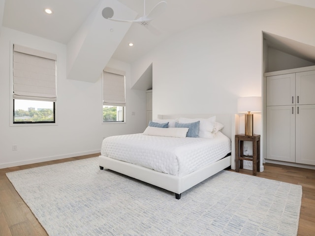 bedroom featuring ceiling fan, vaulted ceiling, and light hardwood / wood-style flooring