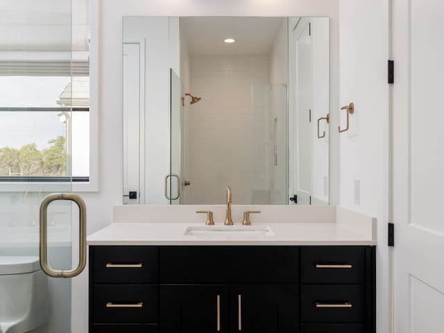 bathroom featuring vanity, toilet, and a shower with door