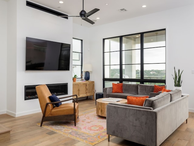 living room with ceiling fan and light hardwood / wood-style flooring