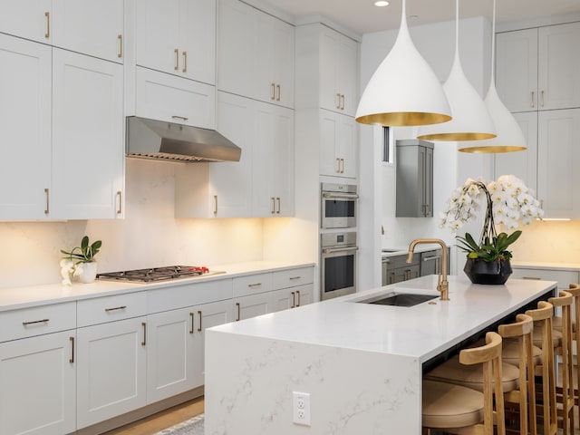 kitchen featuring decorative light fixtures, white cabinetry, sink, and stainless steel appliances