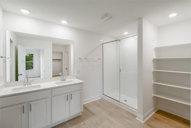 bathroom featuring a stall shower, a sink, and wood finished floors