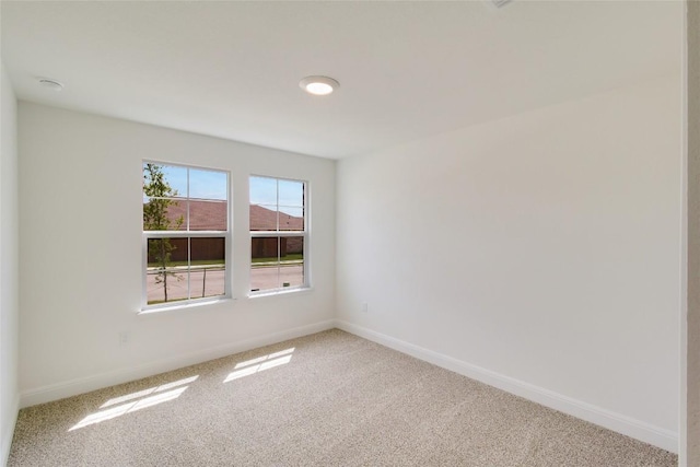 unfurnished room with carpet floors and baseboards