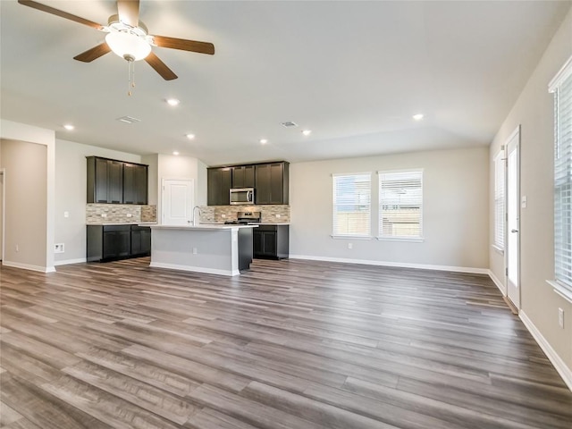 unfurnished living room featuring wood-type flooring and ceiling fan