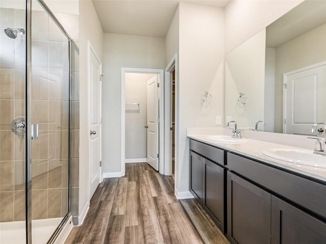 bathroom featuring hardwood / wood-style floors, vanity, and a shower with shower door