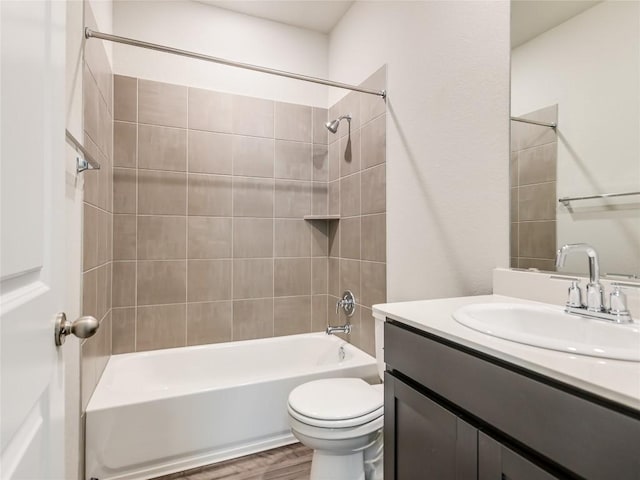 full bathroom with hardwood / wood-style flooring, vanity, toilet, and tiled shower / bath combo