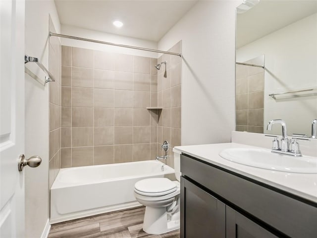 full bathroom featuring vanity, toilet, tiled shower / bath, and hardwood / wood-style flooring