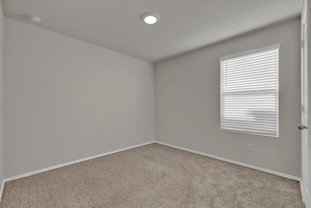 unfurnished room with carpet floors and baseboards