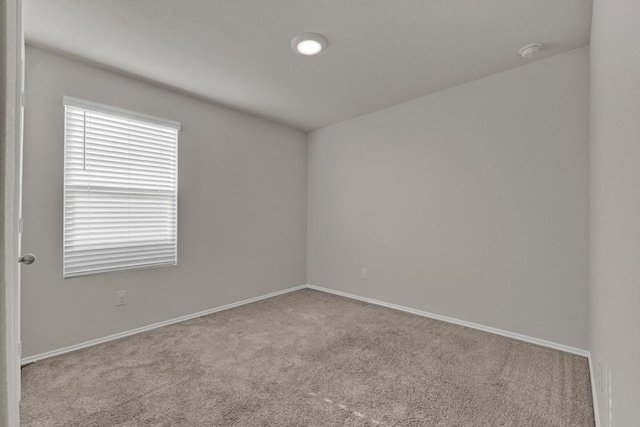 unfurnished room with baseboards and carpet