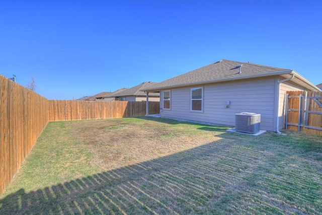 rear view of property with a lawn, a fenced backyard, and cooling unit
