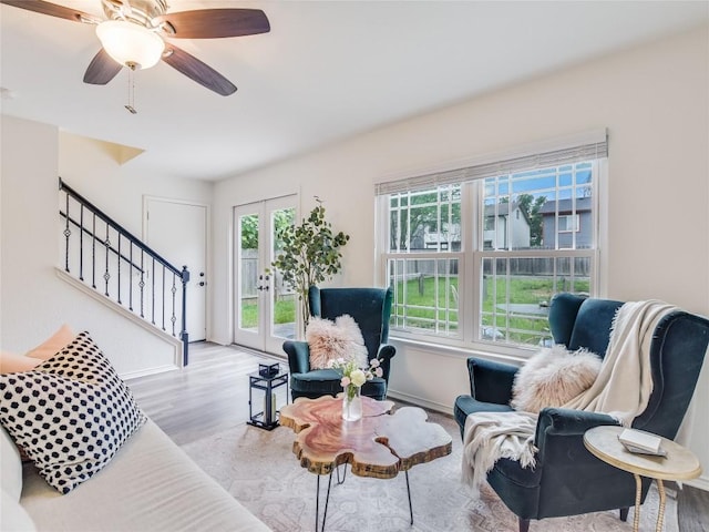 living room featuring ceiling fan, french doors, and light hardwood / wood-style floors