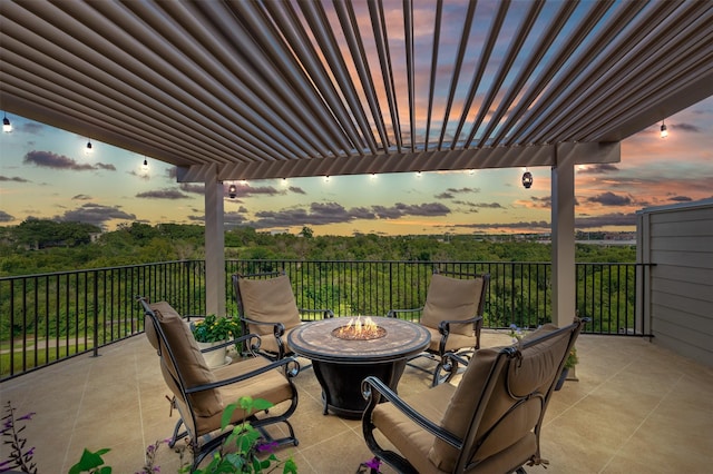 patio terrace at dusk featuring a pergola and a fire pit