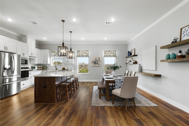 dining space with sink, dark hardwood / wood-style flooring, ornamental molding, and a notable chandelier