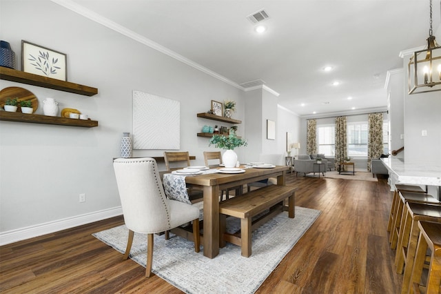 dining room featuring dark wood-type flooring, crown molding, and a chandelier