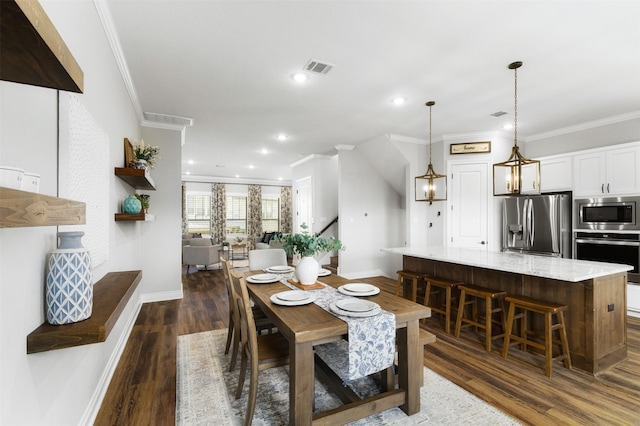 dining space featuring dark wood-type flooring and crown molding