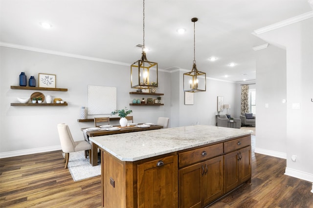 kitchen featuring dark hardwood / wood-style flooring, ornamental molding, pendant lighting, light stone counters, and a center island