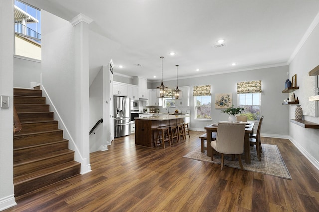 dining area with dark hardwood / wood-style floors and crown molding