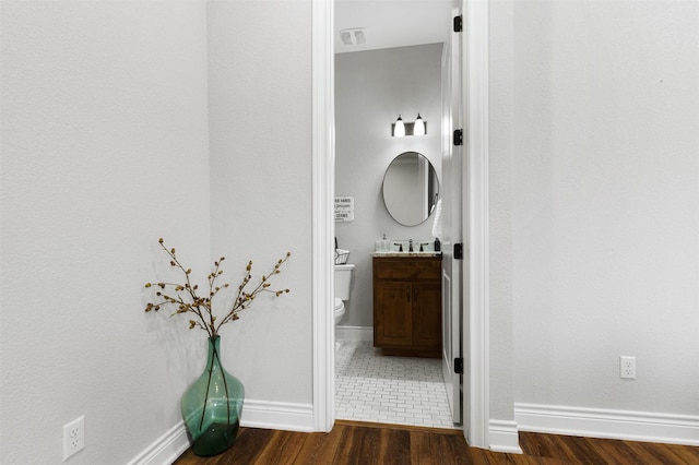 bathroom with wood-type flooring, toilet, and vanity