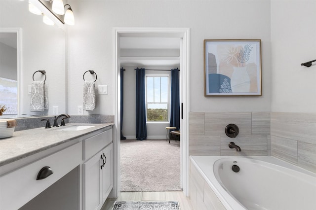 bathroom with a relaxing tiled tub and vanity