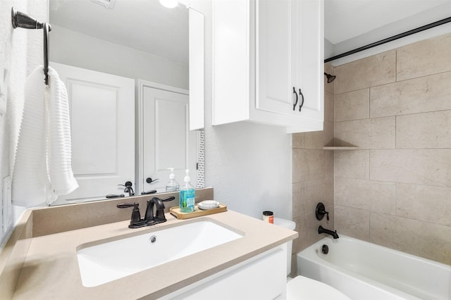 full bathroom featuring toilet, tiled shower / bath, and vanity