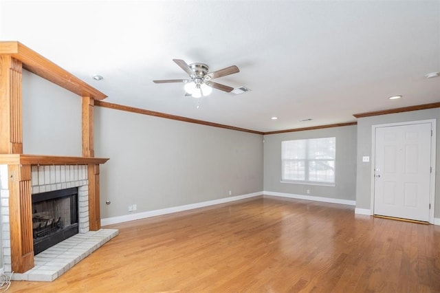 unfurnished living room featuring crown molding, a fireplace, ceiling fan, and light wood-type flooring