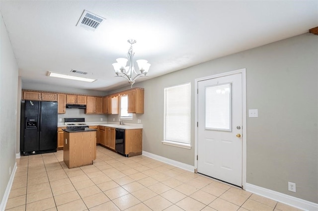 kitchen featuring black appliances, pendant lighting, a chandelier, a kitchen island, and light tile patterned flooring