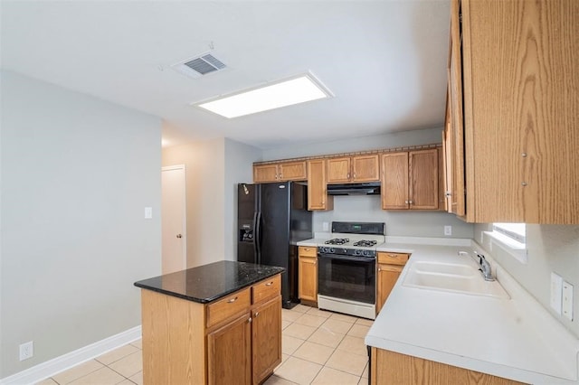 kitchen with a center island, sink, white range with gas stovetop, black fridge with ice dispenser, and light tile patterned floors