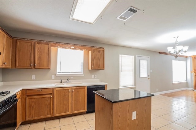 kitchen featuring a wealth of natural light, sink, black appliances, and a notable chandelier