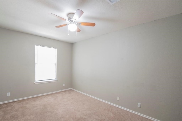 spare room featuring ceiling fan and light carpet