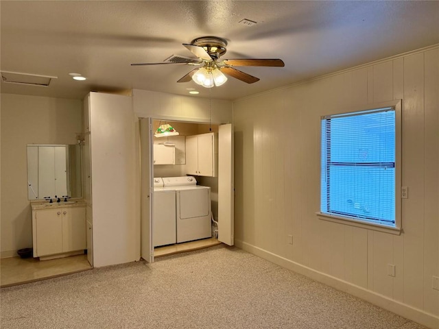 clothes washing area featuring washer and clothes dryer, ceiling fan, and cabinets