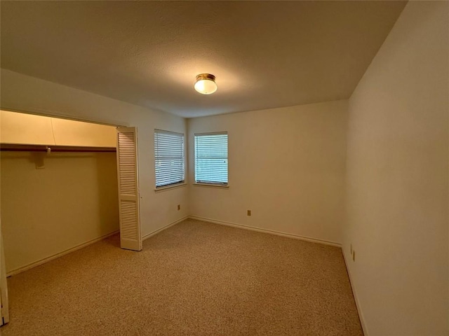 unfurnished bedroom with light carpet and a closet