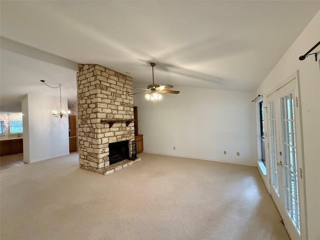 unfurnished living room with french doors, light colored carpet, vaulted ceiling, a fireplace, and ceiling fan with notable chandelier