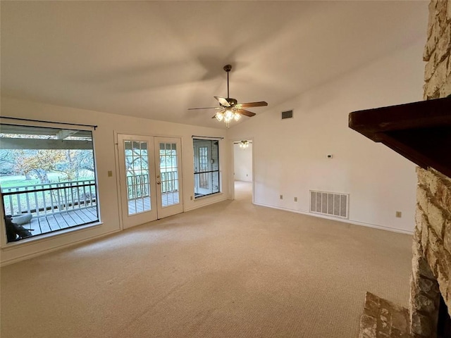 unfurnished living room featuring ceiling fan, french doors, light carpet, and vaulted ceiling