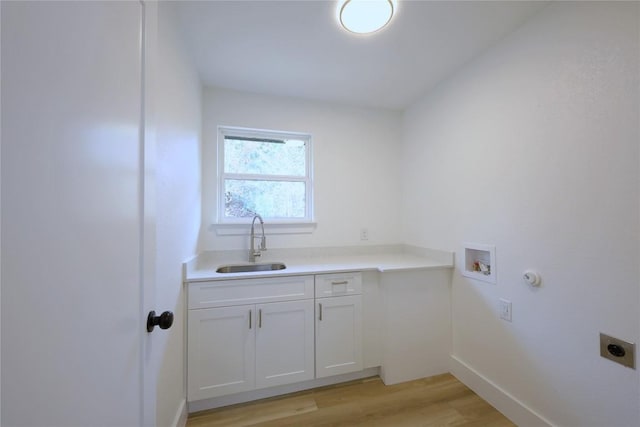 clothes washing area with cabinets, sink, hookup for a washing machine, light wood-type flooring, and hookup for an electric dryer