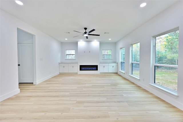 unfurnished living room with light hardwood / wood-style floors, a wealth of natural light, and ceiling fan