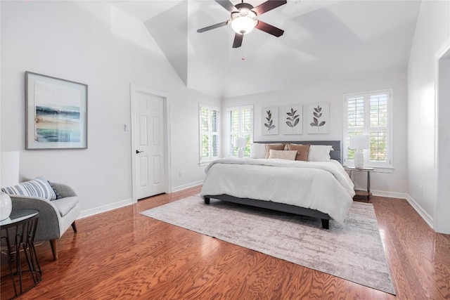 bedroom featuring hardwood / wood-style floors, ceiling fan, and high vaulted ceiling