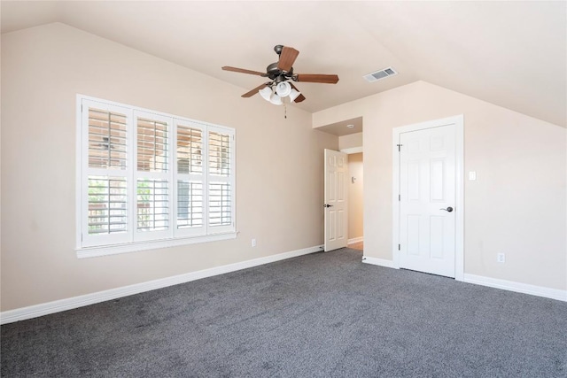 unfurnished bedroom with ceiling fan, dark carpet, and lofted ceiling